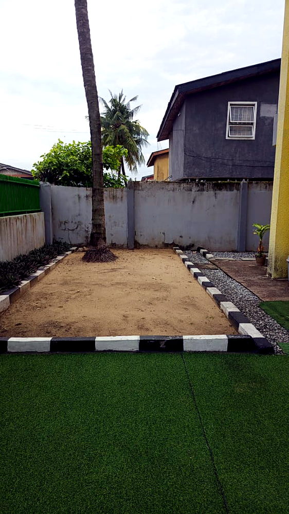 Sand play area under a palm tree at Flourish Playhouse