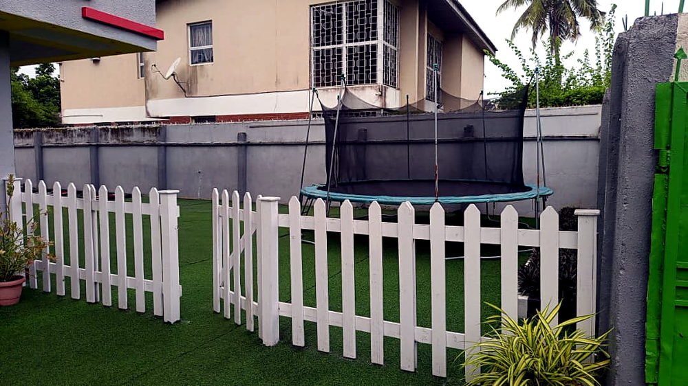 Trampoline behind the white picket fence at Flourish Playhouse